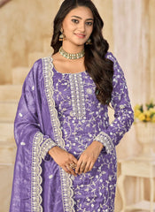 Woman wearing a purple embroidered outfit with a neutral background