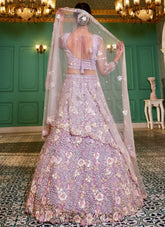 Woman in a floral embroidered lehenga with a matching dupatta in an elegant indoor setting.