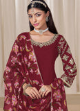 Woman wearing a maroon embroidered traditional outfit with a matching dupatta against a neutral background