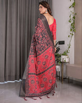 Woman wearing a red and black patterned dupatta in a modern interior setting