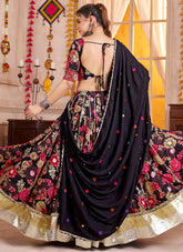 Woman in a black and floral saree with a colorful background
