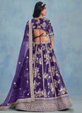 Woman wearing a purple embroidered traditional outfit with a blue gradient background