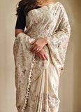 Cream pure loom tussar silk saree with all over embroidery, gold zari border and tassels
