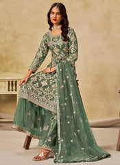 Woman wearing a green embroidered traditional outfit with a beige background