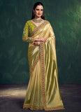 Woman wearing a traditional green and gold saree with a dark background
