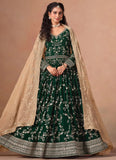 Woman wearing a green traditional outfit with a beige dupatta on a beige background