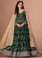 Woman wearing a green traditional outfit with a beige dupatta on a beige background