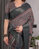 Woman wearing a traditional saree with intricate patterns in a home setting