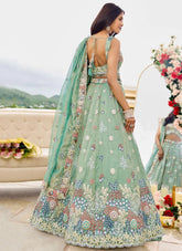 Woman in a light green embroidered dress with a floral background