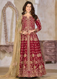 Woman wearing a red embroidered traditional outfit with a beige dupatta in a decorative setting.