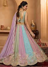 Woman wearing a colorful embroidered traditional outfit in a decorated room.