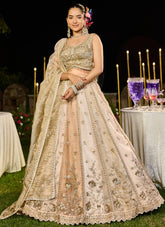 Woman in a traditional embroidered outfit standing outdoors with decorative lights and tableware in the background.