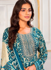 Woman wearing a teal and beige patterned outfit with embroidery.