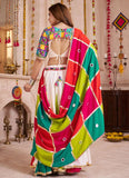 Woman wearing a colorful traditional outfit in a decorated indoor setting