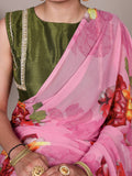 Person wearing a green blouse with a pink saree featuring floral patterns.