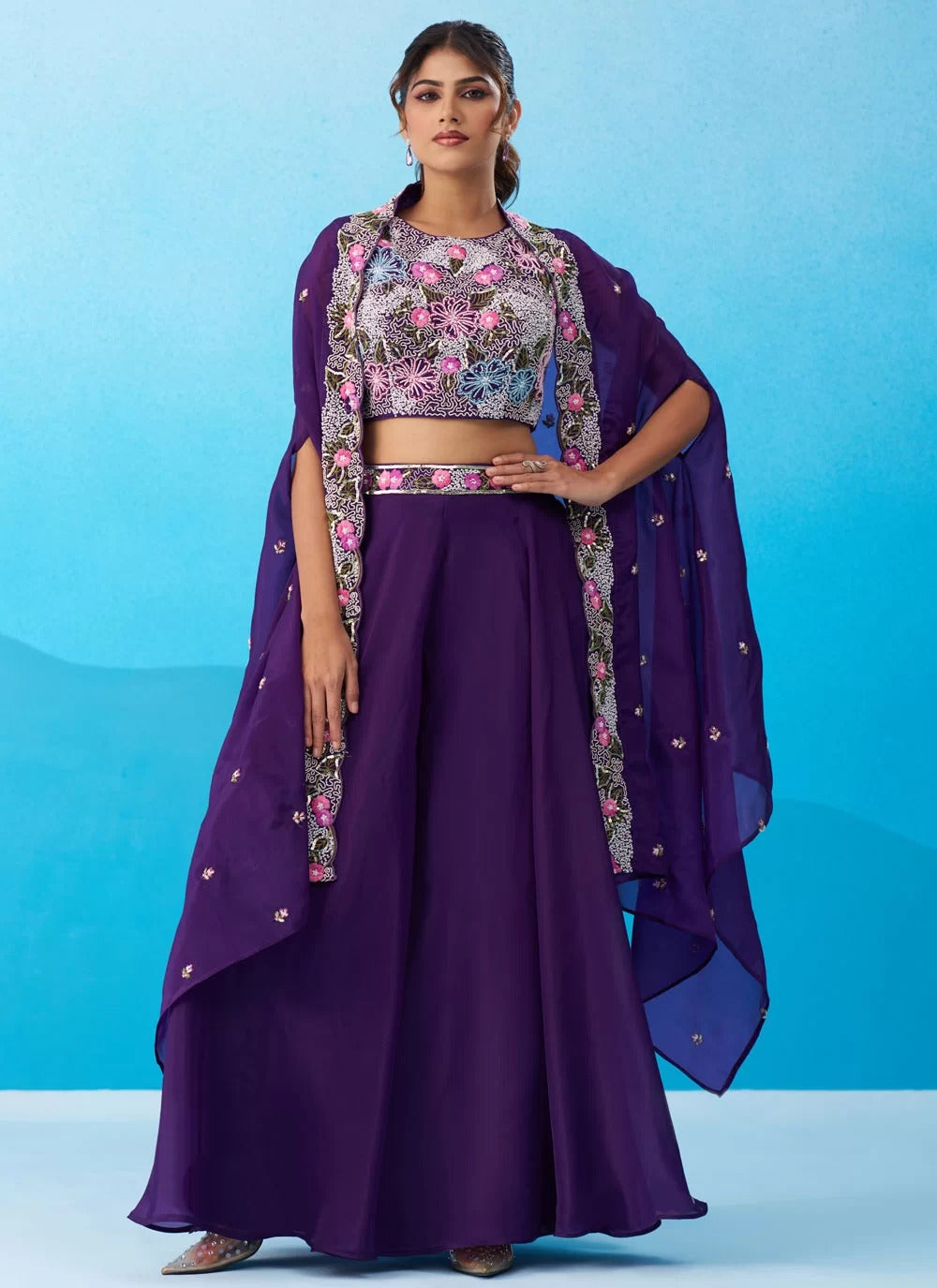 Woman wearing a purple traditional outfit with a floral blouse against a blue background