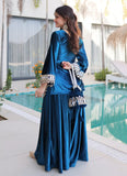 Woman in a blue traditional outfit standing by a poolside.