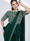 Woman wearing a green saree with a matching blouse against a white background
