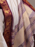 Close-up of a fabric with purple and gold patterns on a white background