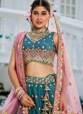 Woman in traditional embroidered outfit with pink dupatta and jewelry