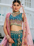 Woman in traditional embroidered outfit with pink dupatta and jewelry