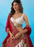 Close-up of intricate zari, sequins and thread embroidery on a white Chinnon Silk designer lehenga