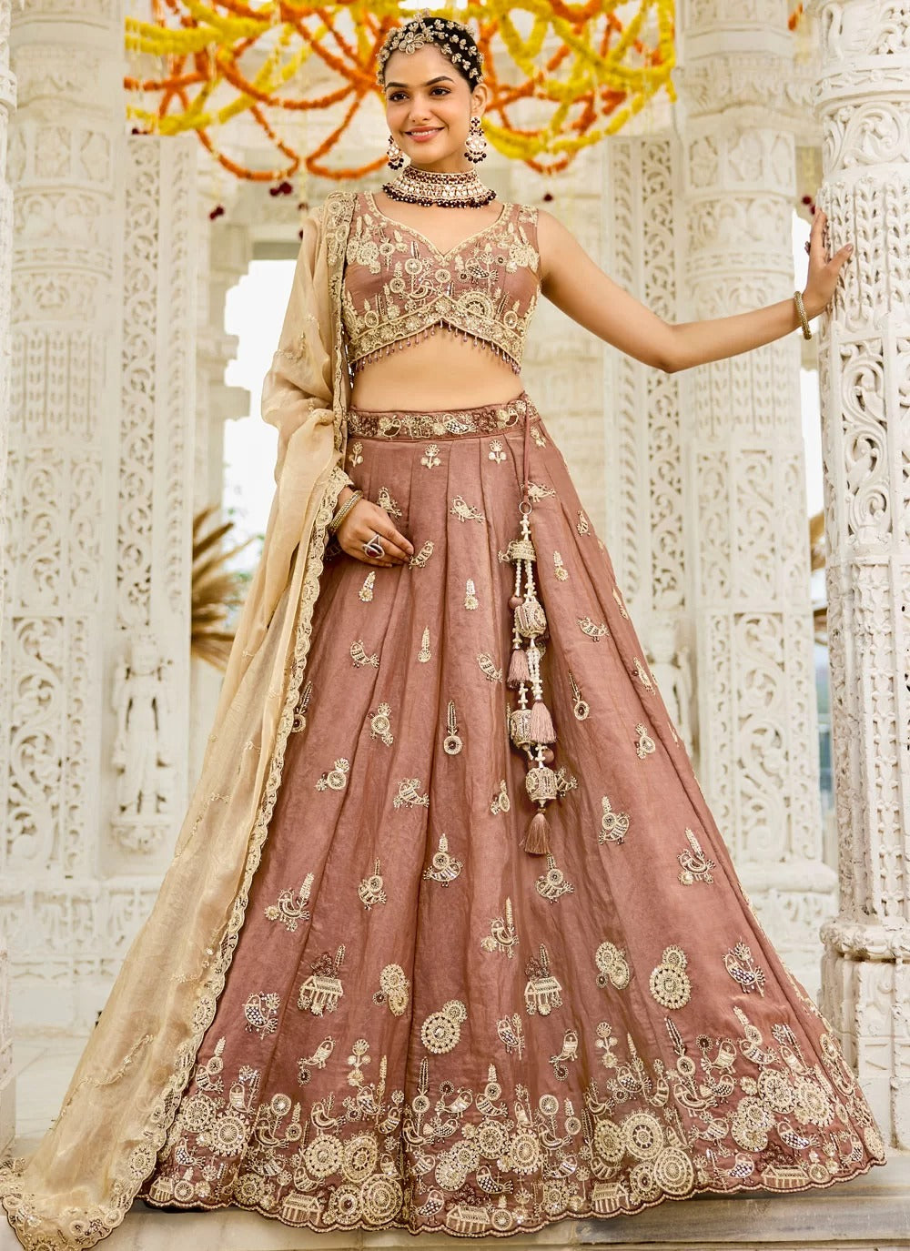 Woman in traditional embroidered outfit standing against a decorative background