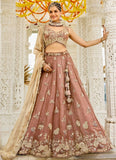 Woman in traditional embroidered outfit standing against a decorative background