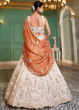 Woman in a traditional embroidered outfit with a saree in an elegant room.