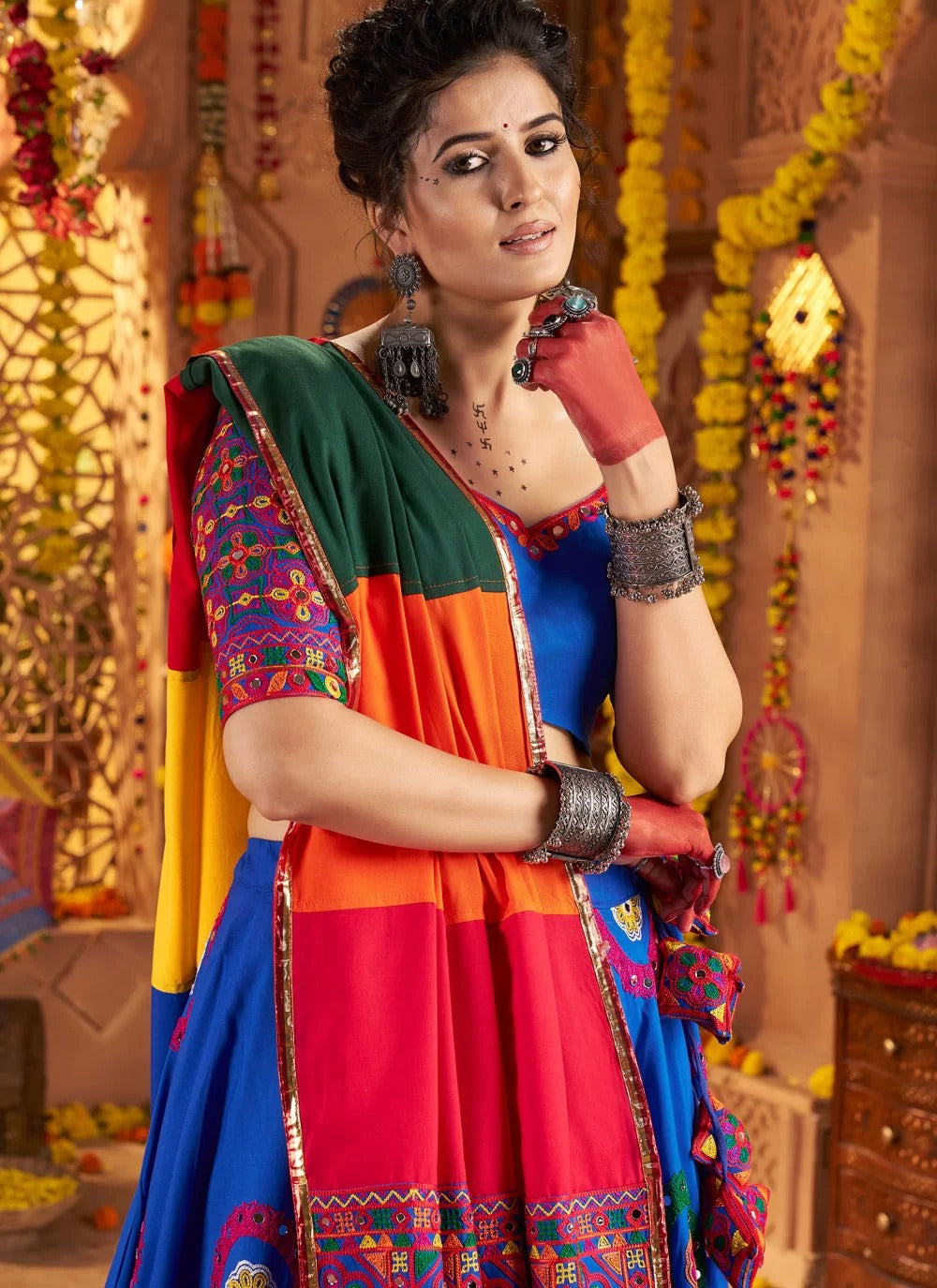 Woman in a colorful traditional outfit with decorative background