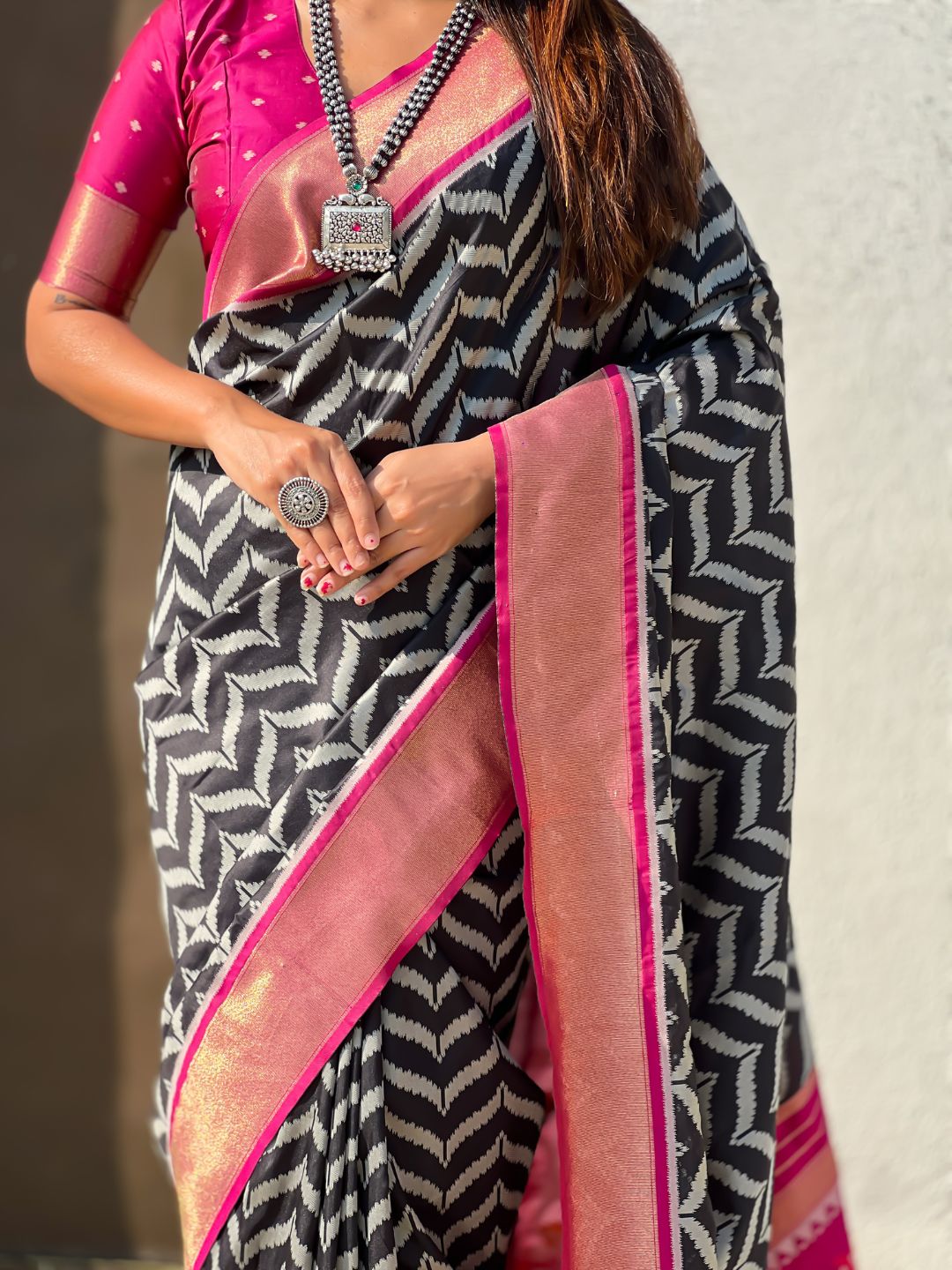 designer black silk saree with heritage motifs and contrast blouse
