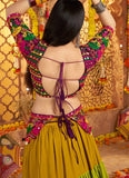 Woman in a colorful traditional outfit with a decorative background