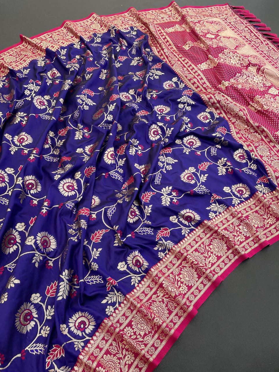 Blue floral patterned fabric with pink and white border on a gray background