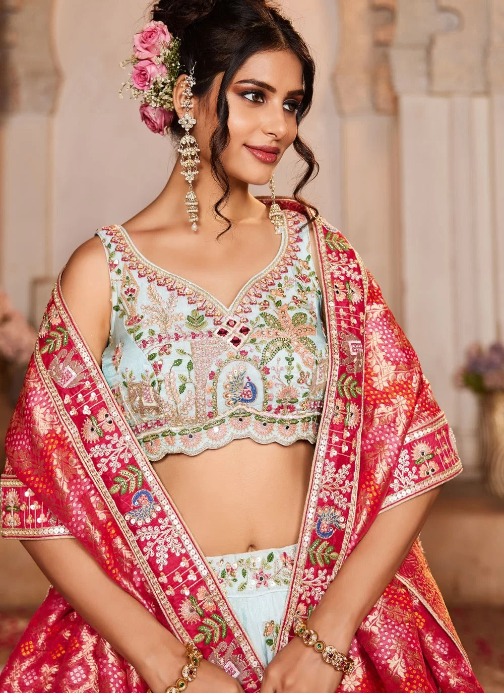 Woman wearing a traditional embroidered outfit with a floral headpiece indoors.