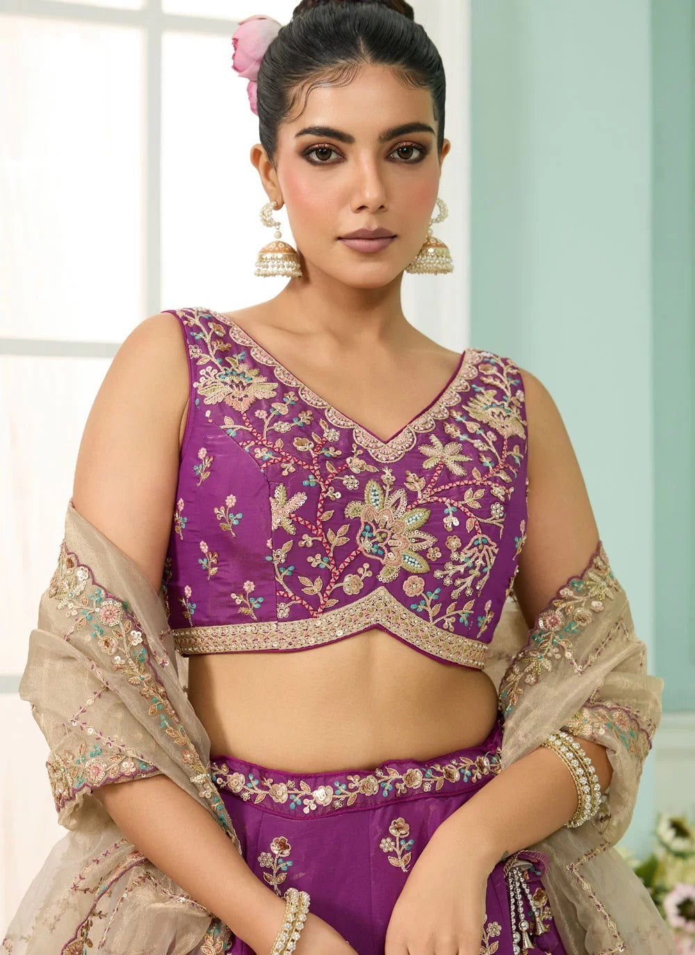 Woman wearing a purple embroidered traditional outfit with a beige dupatta.