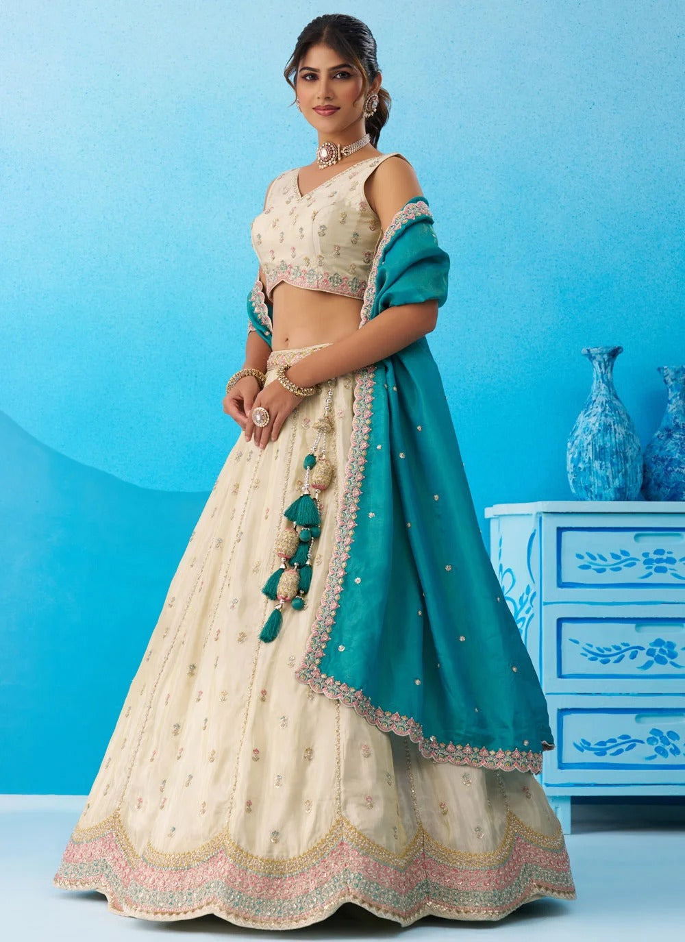 Cream wedding lehenga for women featuring heavy sequins embroidery, premium tissue fabric and contrasting Rama tissue dupatta.