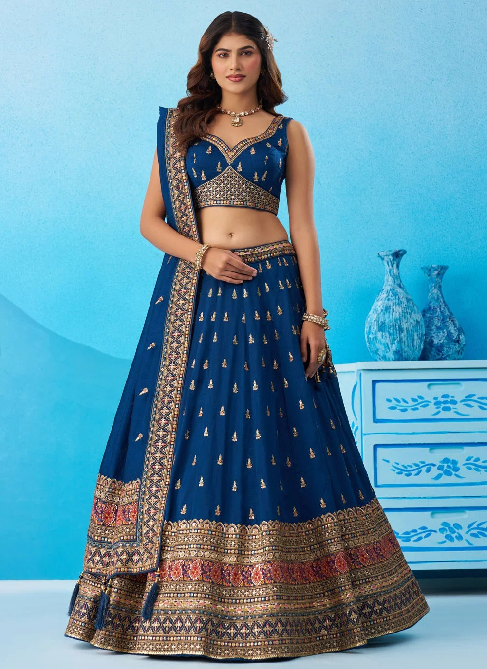 Designer engagement lehenga in morpeach Chinnon Silk featuring sequins, thread and zari embroidery with a matching embroidered dupatta and decorative tassels.