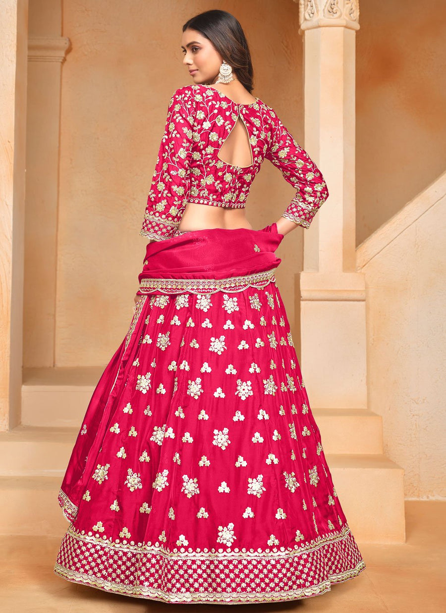 Woman wearing a pink and white floral traditional outfit in an indoor setting.