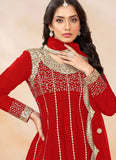 Woman wearing a red traditional outfit with gold embroidery on a beige background