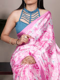 Woman wearing a pink floral saree with a blue blouse against a neutral background