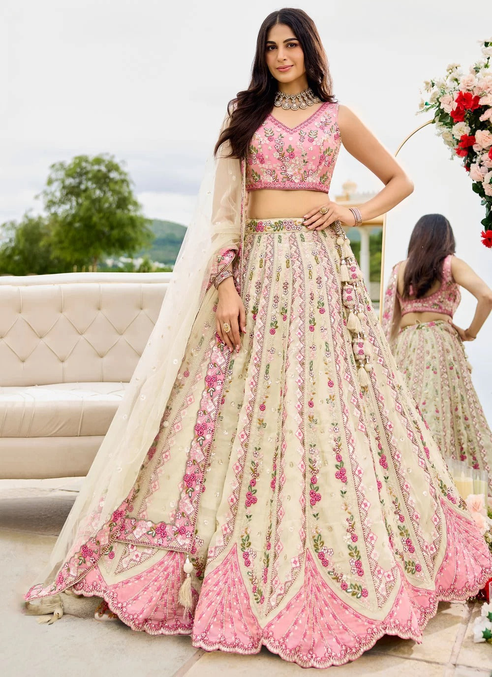 Woman wearing a floral pink and beige lehenga with a matching blouse.