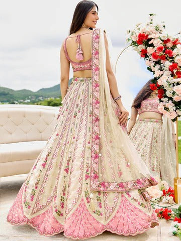Cream tissue bridesmaid lehenga with sequins, stone work, embroidered blouse and net dupatta, featuring heavy flare and handmade latkan