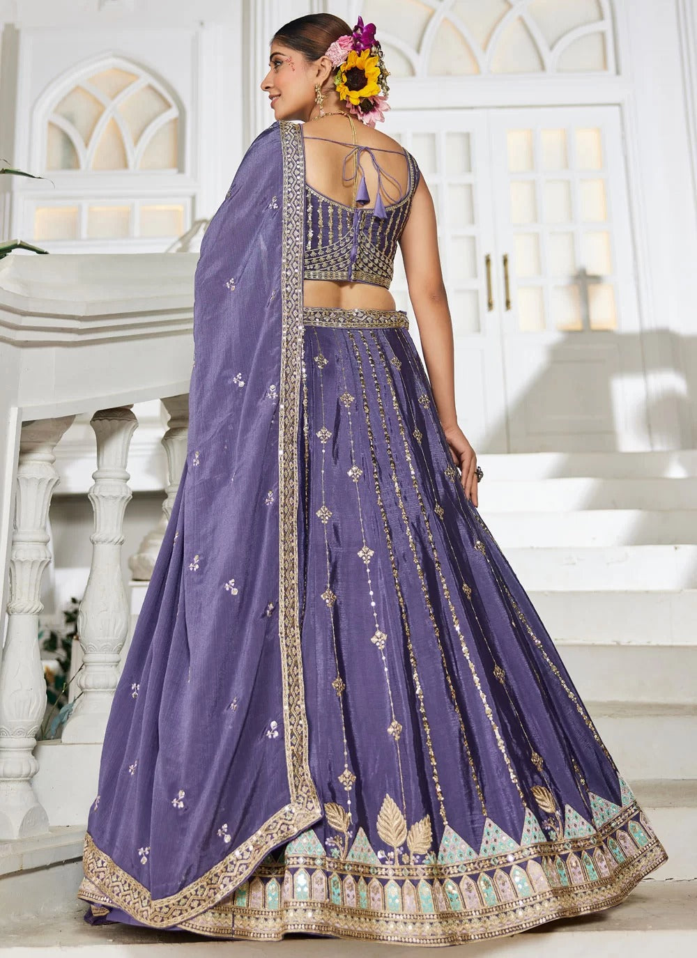 Woman in a purple embroidered traditional outfit with a white background