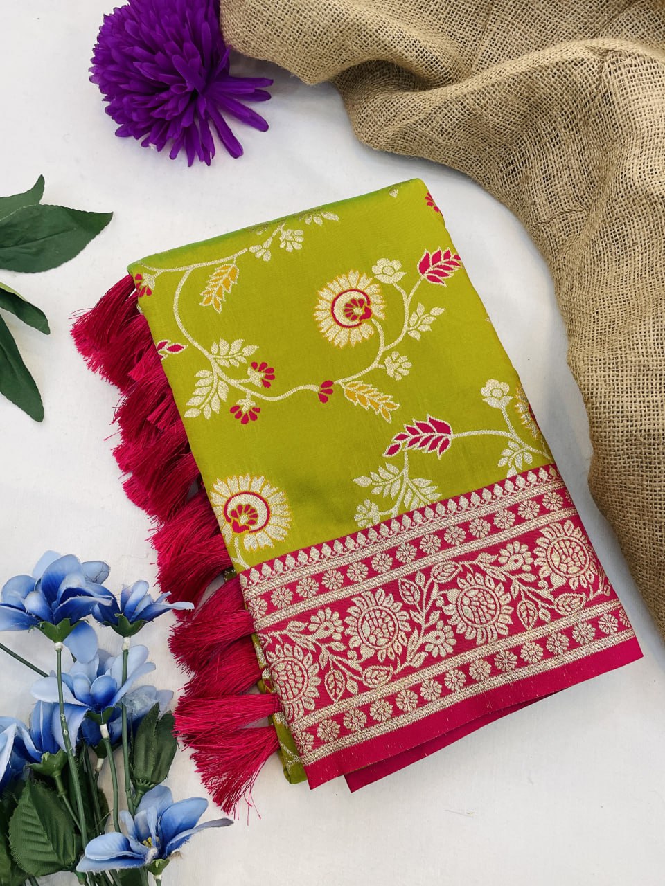 Green and pink patterned fabric with tassels on a white background