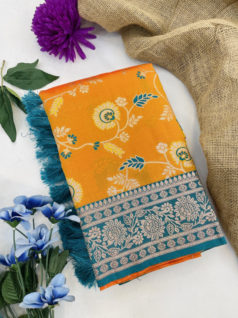 Orange fabric with floral pattern and blue border on a white background