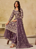 Woman wearing a purple traditional outfit with floral patterns in a neutral setting