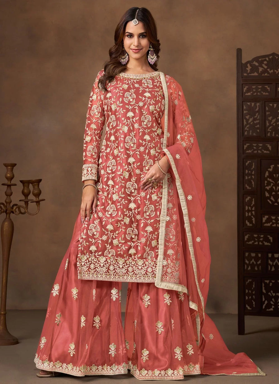 Woman wearing a traditional pink embroidered outfit with a brown background