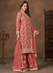 Woman wearing a traditional pink embroidered outfit with a brown background