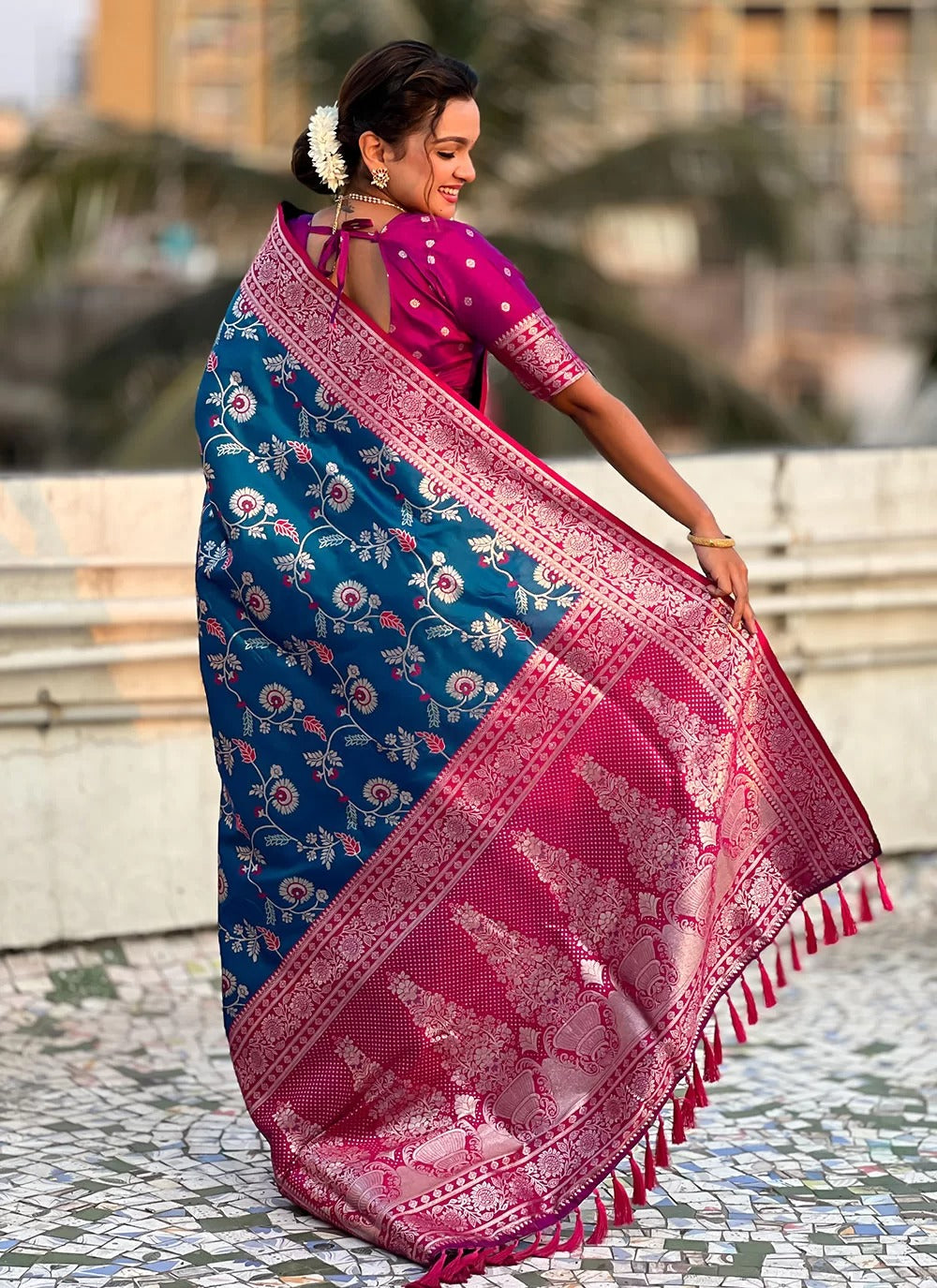 Woman wearing a blue and pink saree with a blurred background