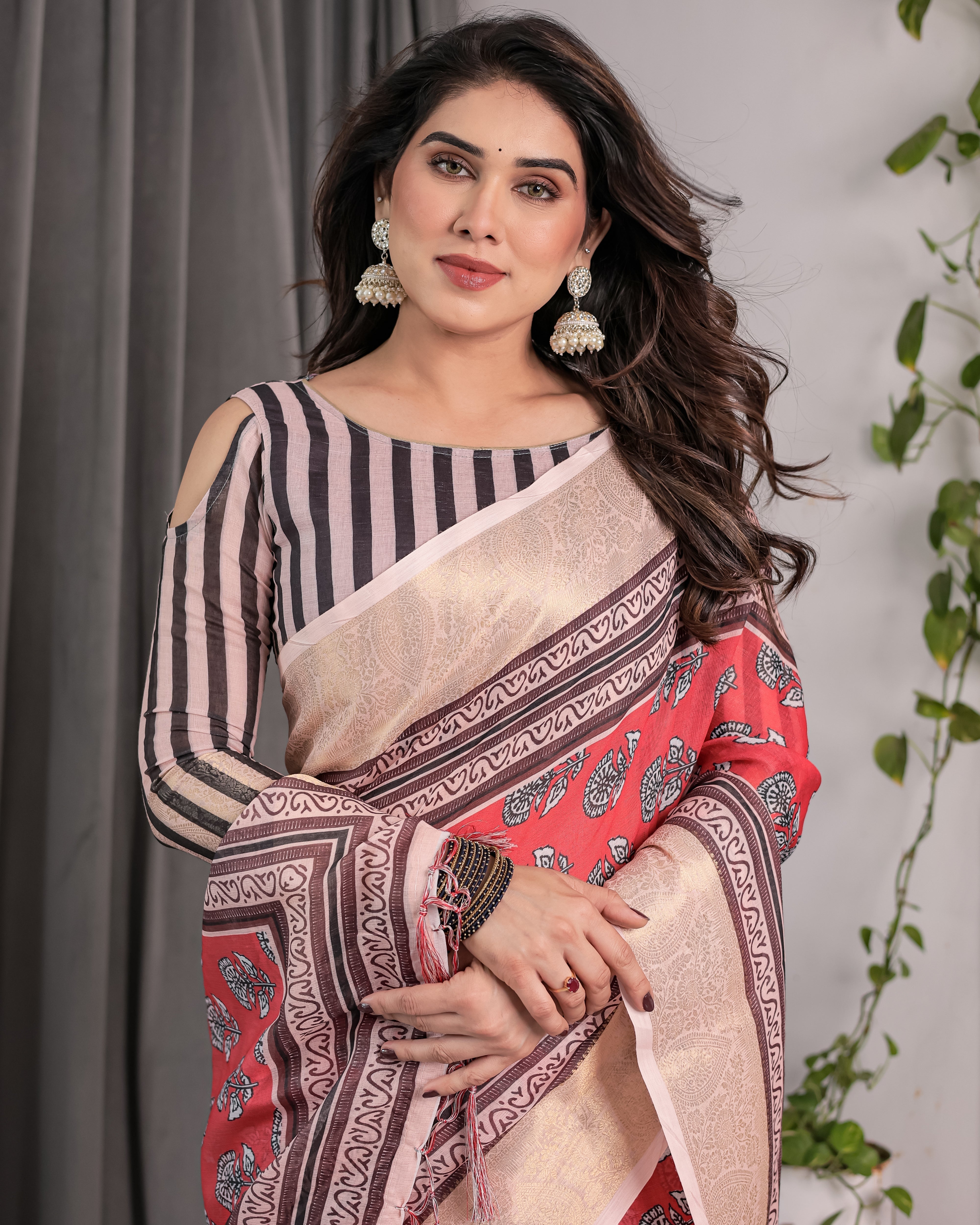 Woman wearing a traditional saree with a striped blouse against a neutral background